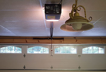 Damaged and misaligned cream-colored garage door before full replacement in Saratoga, CA