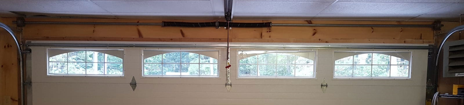 Damaged and misaligned cream-colored garage door before full replacement in Saratoga, CA